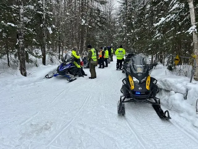 Agents de la Sûreté du Québec dans un sentier de motoneiges.